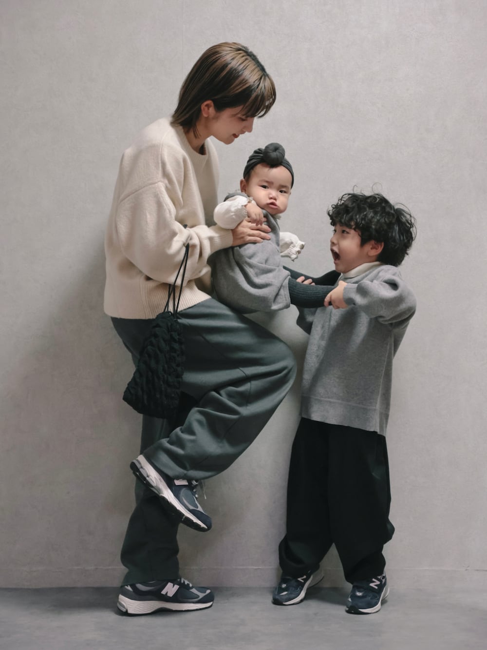 ブルー系のその他アウター、ホワイト系のニット/セーター、ブラック系のショルダーバッグを着用したキッズの秋コーディネートの3枚目の写真