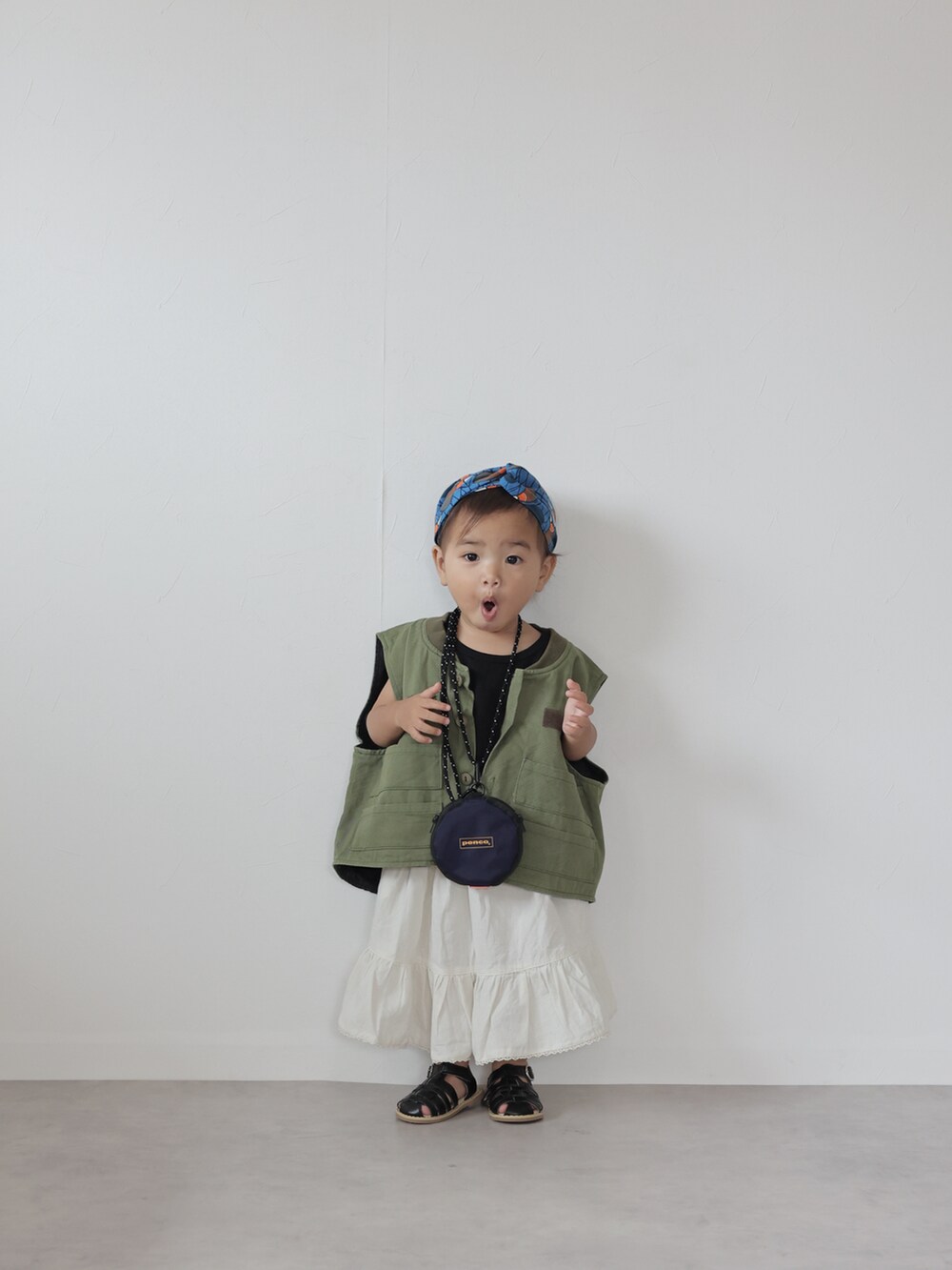 グリーン系のベスト、ブラック系のTシャツ/カットソー、ホワイト系のスカートを着用したキッズの夏コーディネートの5枚目の写真