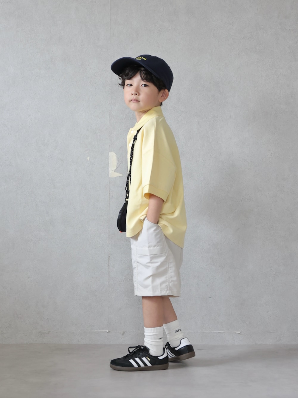 イエロー系のTシャツ/カットソー、ホワイト系のパンツ、ブラック系のスニーカーを着用したキッズの夏コーディネートの2枚目の写真