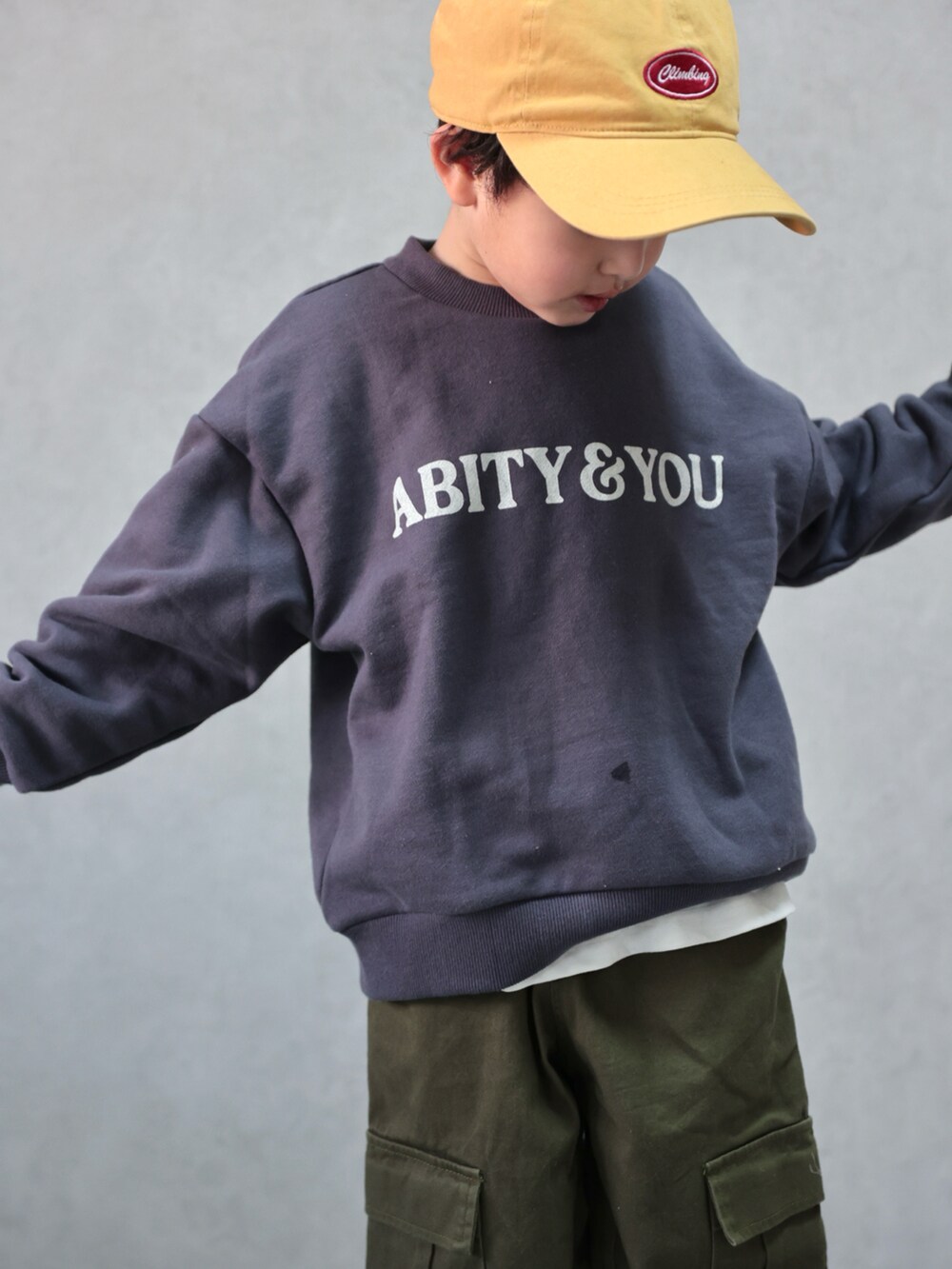 グレー系のスウェット、グリーン系のカーゴパンツ、ホワイト系のスニーカーを着用したキッズの冬コーディネートの4枚目の写真