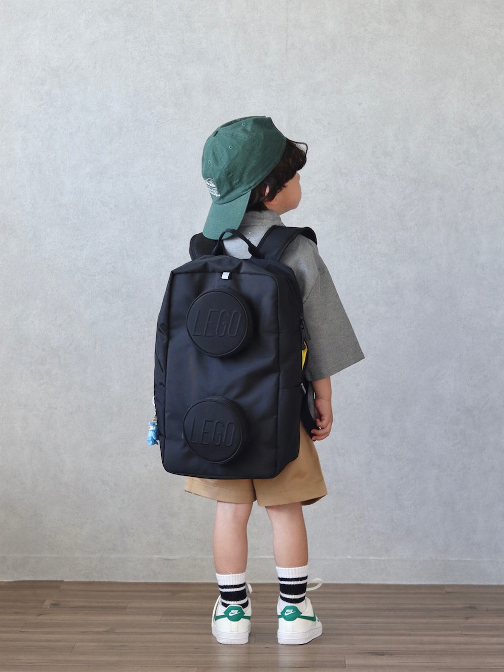 ブラック系のシャツ/ブラウス、ベージュ系のチノパンツ、ベージュ系のスニーカーを着用したキッズの春コーディネートの3枚目の写真