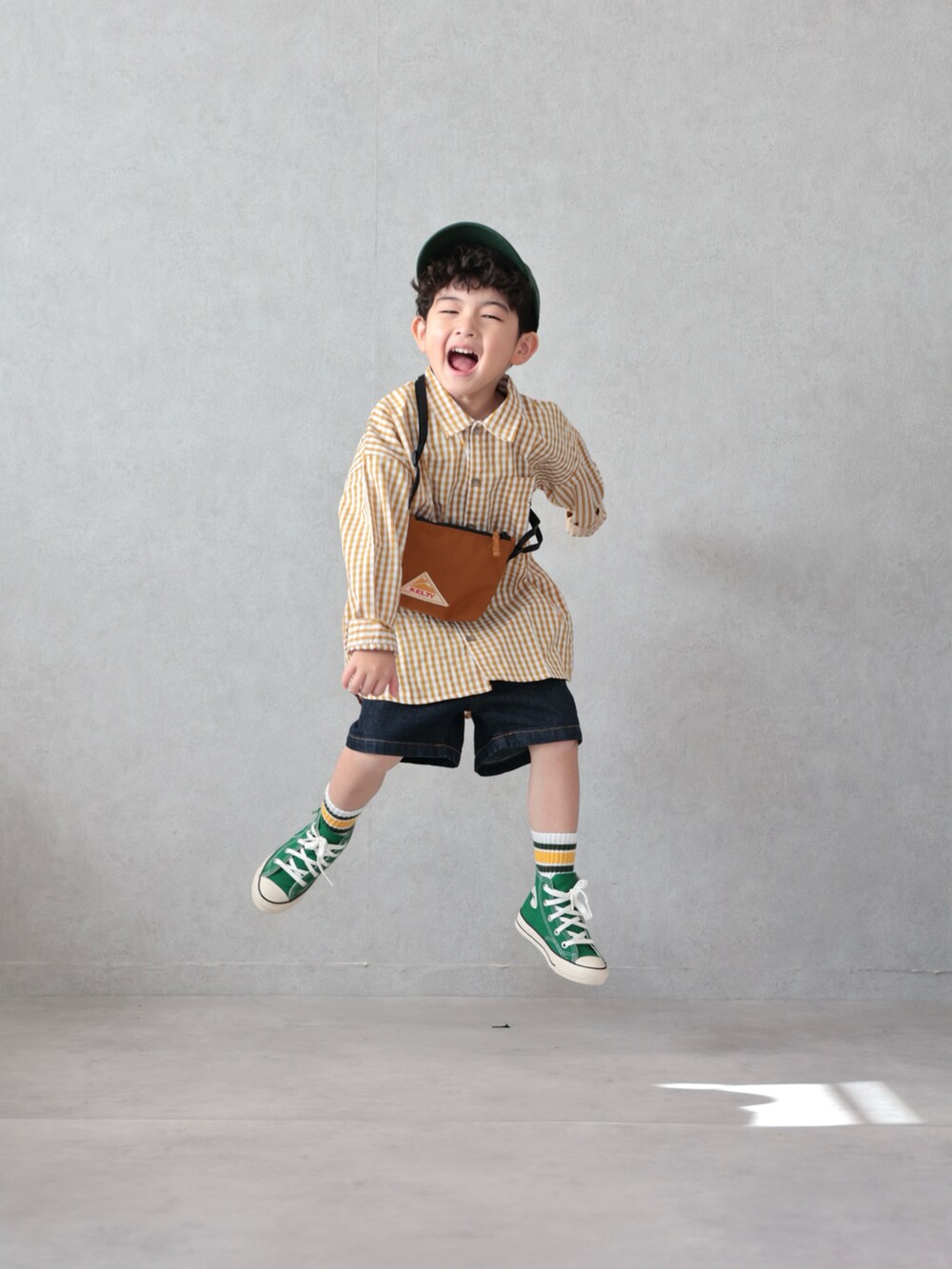 イエロー系のシャツ/ブラウス、ブルー系のデニムパンツ、グリーン系のスニーカーを着用したキッズの春コーディネートの4枚目の写真