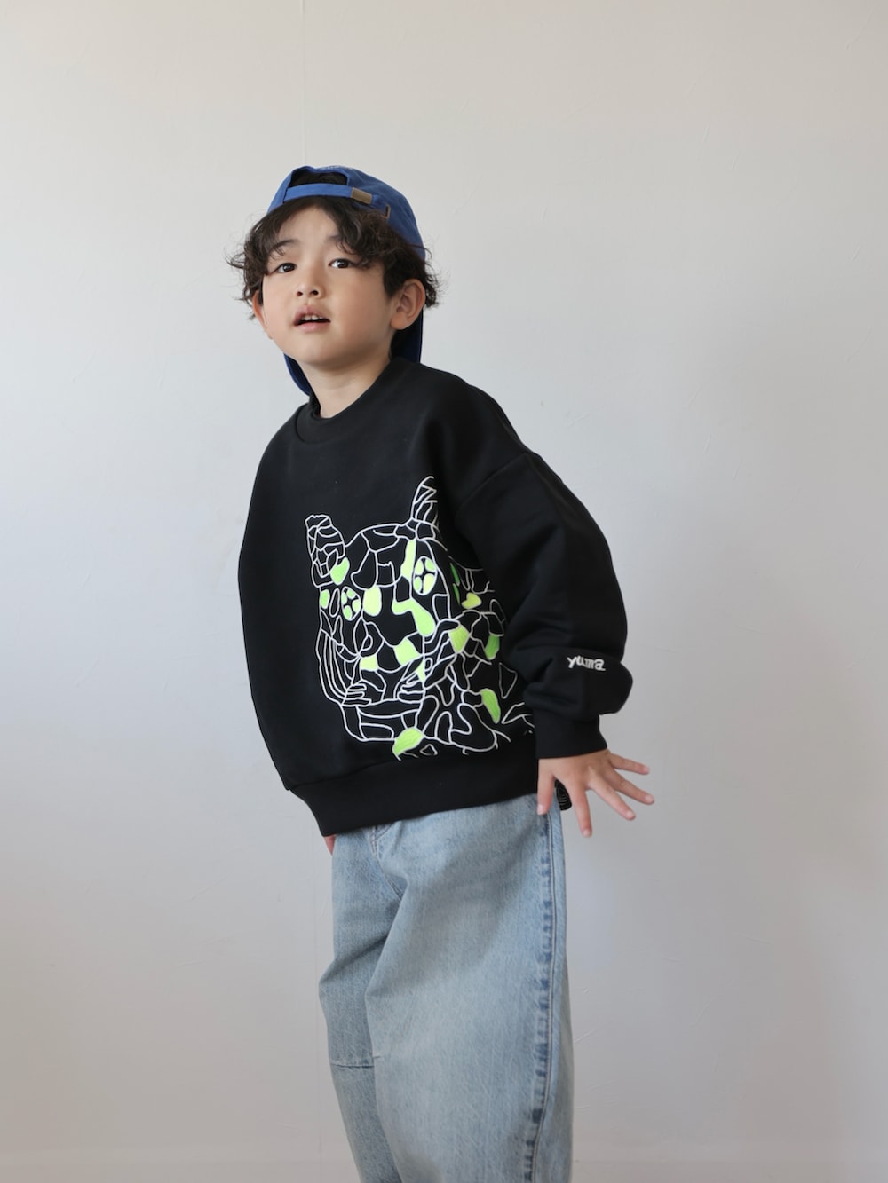 ブラック系のスウェット、ブルー系のデニムパンツ、ブラック系のスニーカーを着用したキッズの冬コーディネートの5枚目の写真