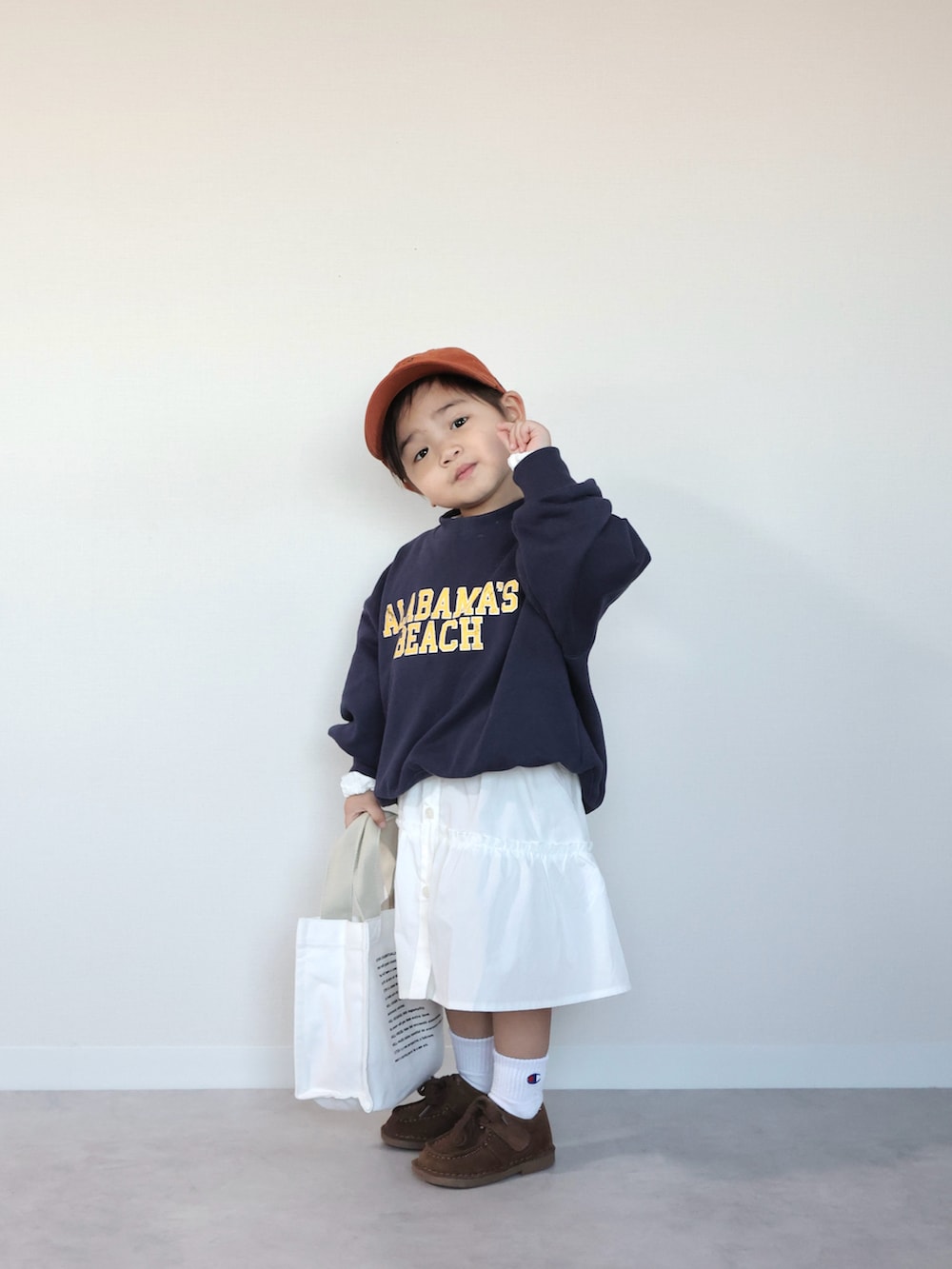 ブラウン系のモカシン/デッキシューズ、ブルー系のスウェット、ホワイト系のワンピースを着用したキッズの冬コーディネートの5枚目の写真