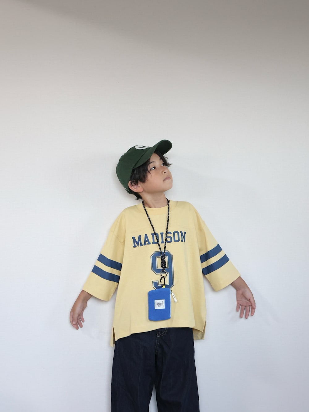 イエロー系のTシャツ/カットソー、ブラック系のスリッポン、ブルー系のパンツを着用したキッズの秋コーディネートの5枚目の写真