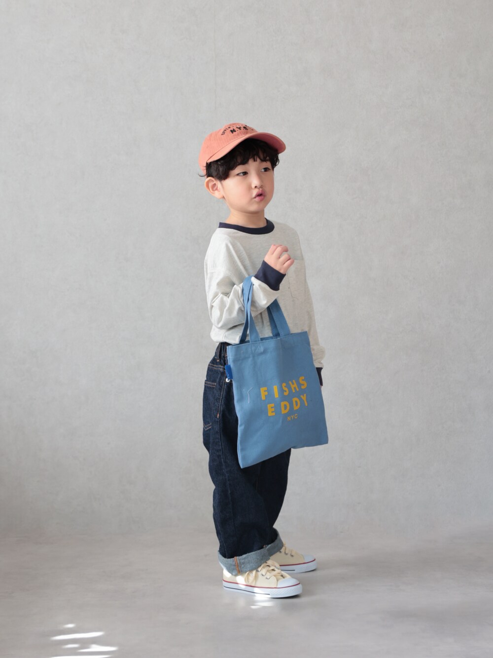 ベージュ系のTシャツ/カットソー、ブルー系のデニムパンツ、ホワイト系のスニーカーを着用したキッズの春コーディネートの3枚目の写真