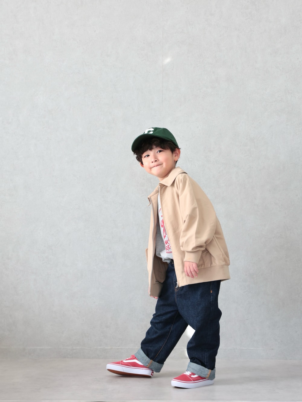 ブラウン系のブルゾン、グレー系のTシャツ/カットソー、ブルー系のデニムパンツを着用したキッズの春コーディネートの3枚目の写真