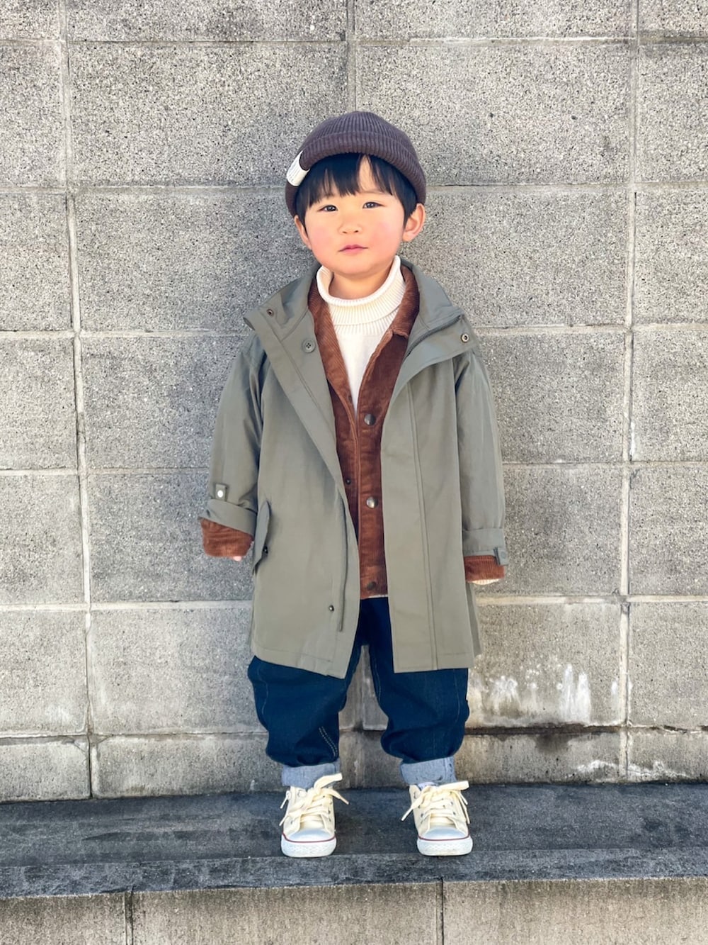 グリーン系のジャケット/アウター、ブラウン系のブルゾン、ホワイト系のニット/セーターを着用したキッズの冬コーディネートの2枚目の写真