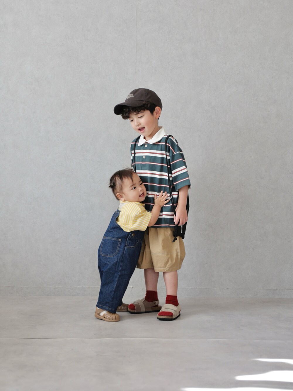 グリーン系のポロシャツ、ベージュ系のその他パンツ、ベージュ系のサンダルを着用したキッズの春コーディネートの4枚目の写真