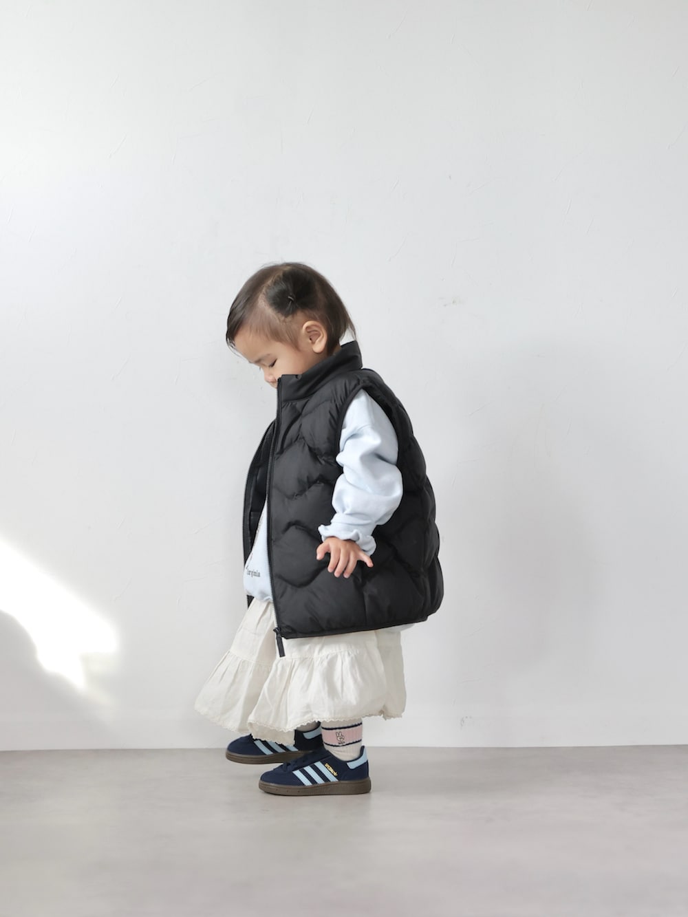 ブルー系のスウェット、ホワイト系のスカート、ブルー系のスニーカーを着用したキッズの冬コーディネートの2枚目の写真