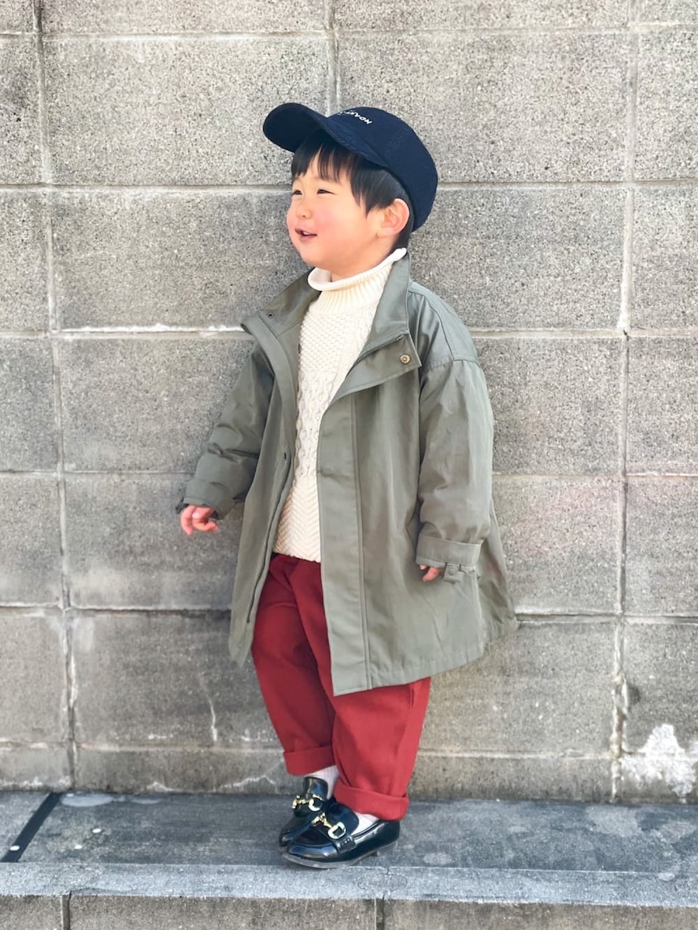 グリーン系のジャケット/アウター、ホワイト系のニット/セーター、ホワイト系のニット/セーターを着用したキッズの冬コーディネートの2枚目の写真