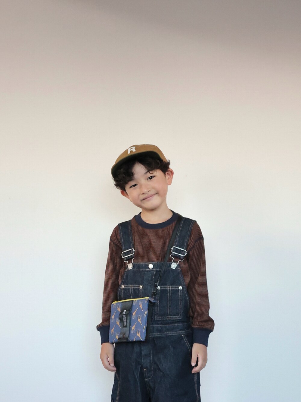 ブルー系のサロペット/オーバーオール、ベージュ系のサンダル、ブラウン系のTシャツ/カットソーを着用したキッズの夏コーディネートの5枚目の写真