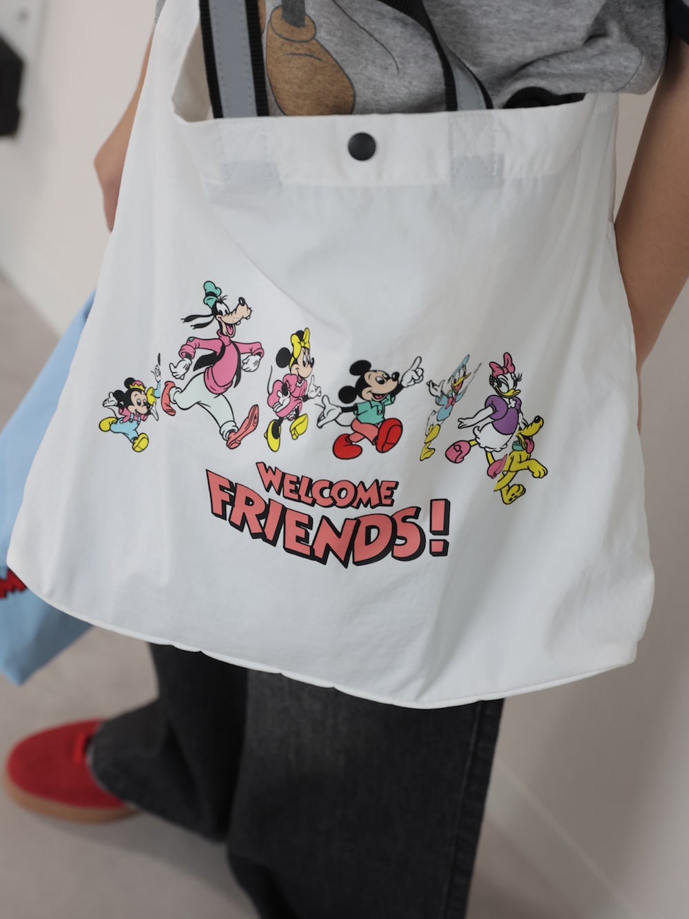 グレー系のTシャツ/カットソー、ブラック系のデニムパンツ、ホワイト系のショルダーバッグを着用したキッズの冬コーディネートの4枚目の写真