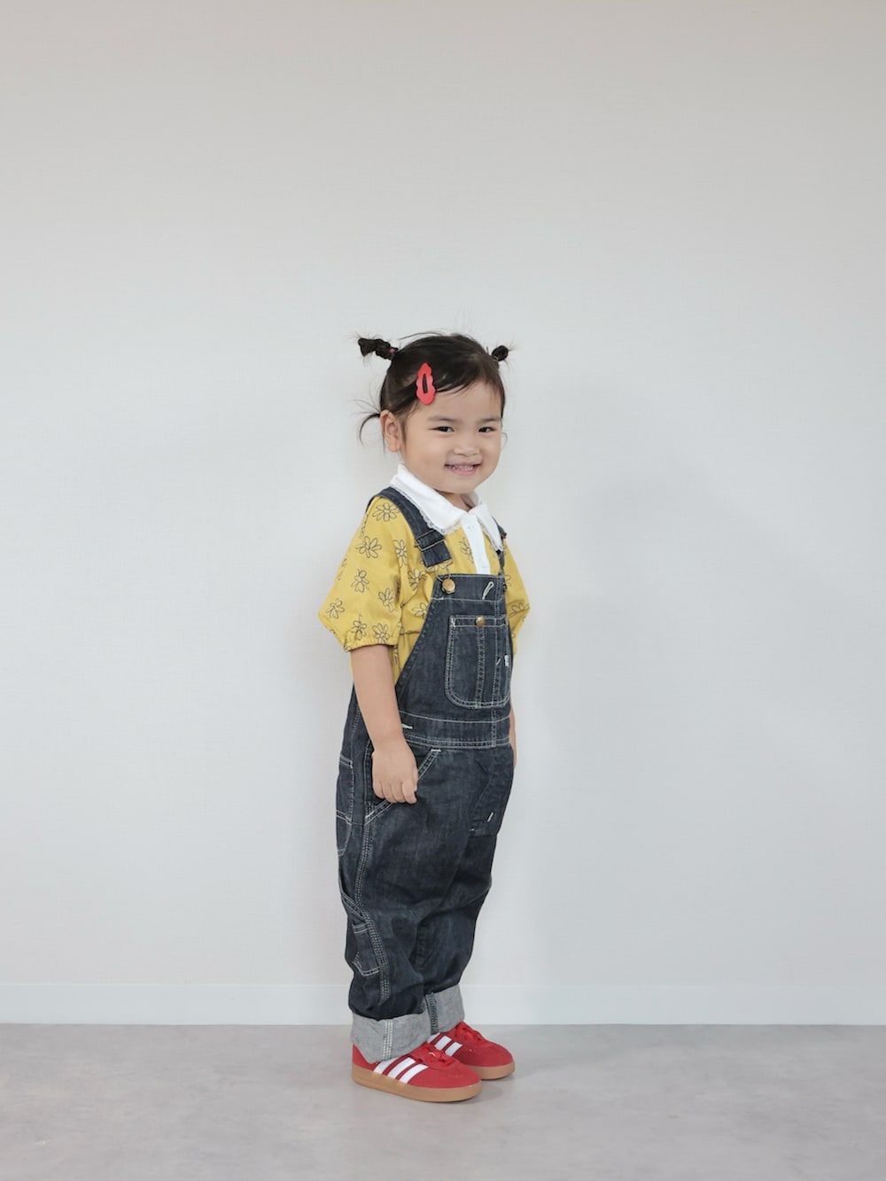 レッド系のスニーカー、イエロー系のTシャツ/カットソー、ブルー系のサロペット/オーバーオールを着用したキッズの夏コーディネートの5枚目の写真