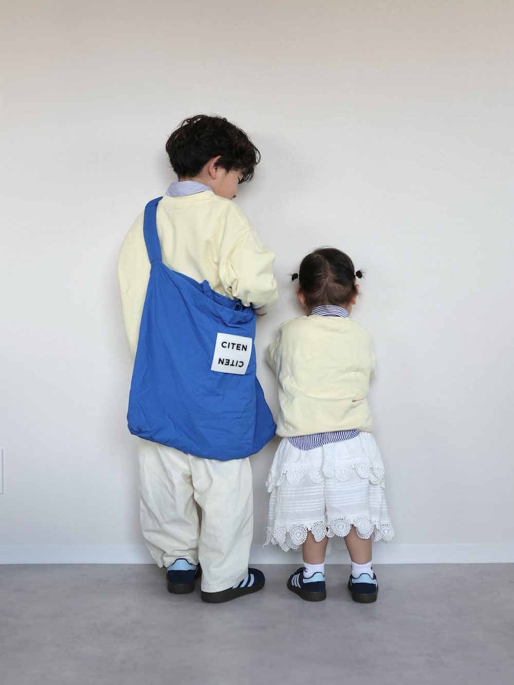 イエロー系のトップス、ブルー系のシャツ/ブラウス、ホワイト系のカーゴパンツを着用したキッズの春コーディネートの5枚目の写真