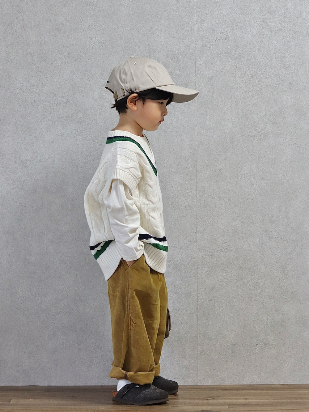 ホワイト系のベスト、ホワイト系のTシャツ/カットソー、ブラウン系のパンツを着用したキッズの秋コーディネートの4枚目の写真