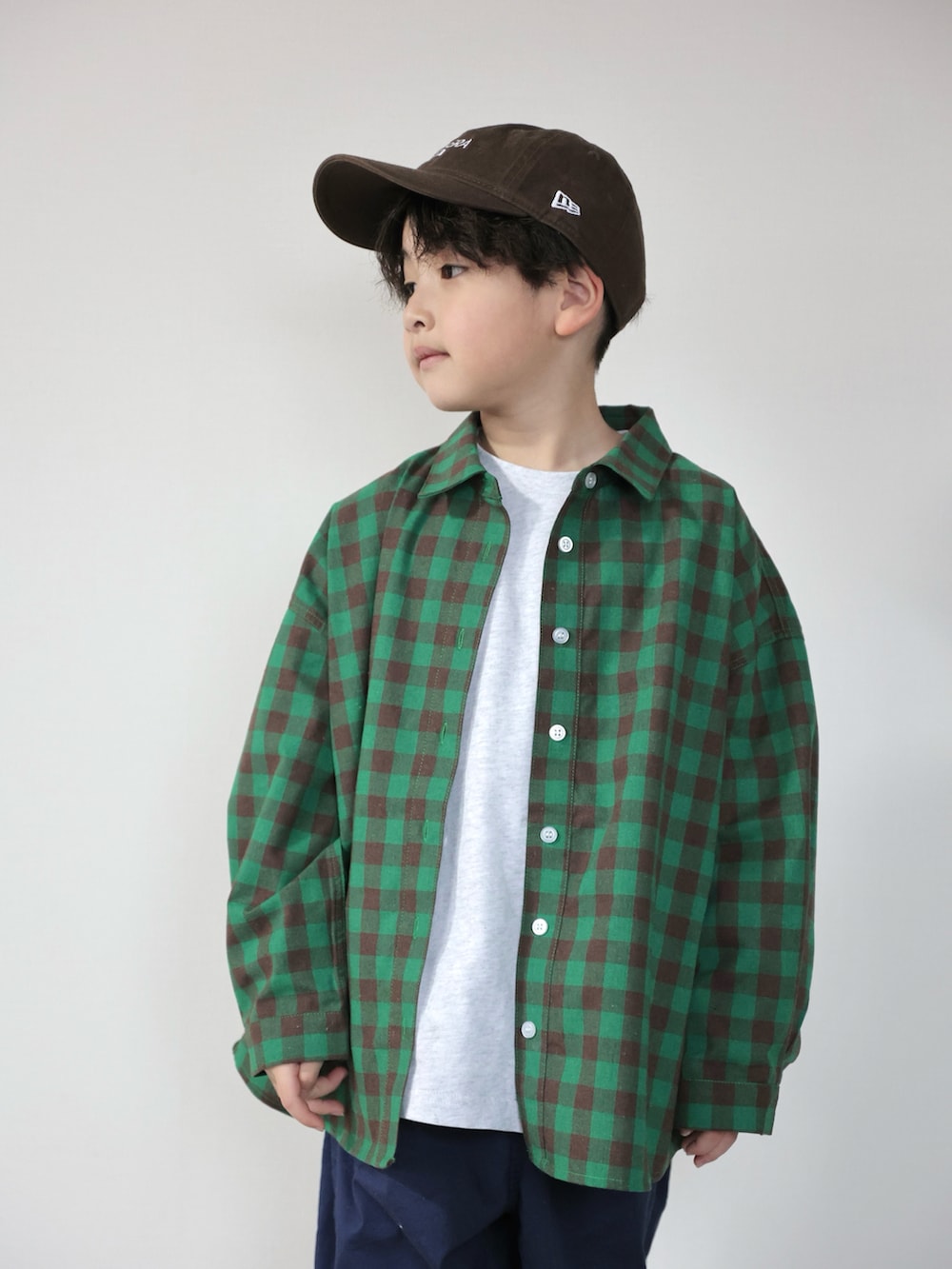 グレー系のTシャツ/カットソー、グリーン系のシャツ/ブラウス、ブルー系のデニムパンツを着用したキッズの冬コーディネートの4枚目の写真