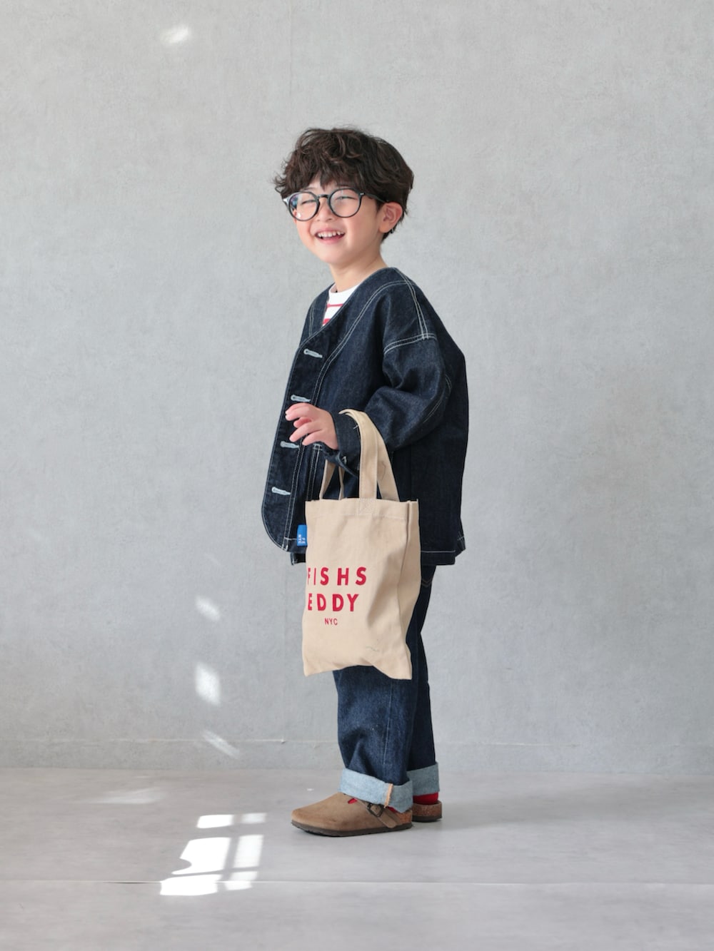 ブルー系のカバーオール、レッド系のTシャツ/カットソー、ブルー系のデニムパンツを着用したキッズの春コーディネートの2枚目の写真