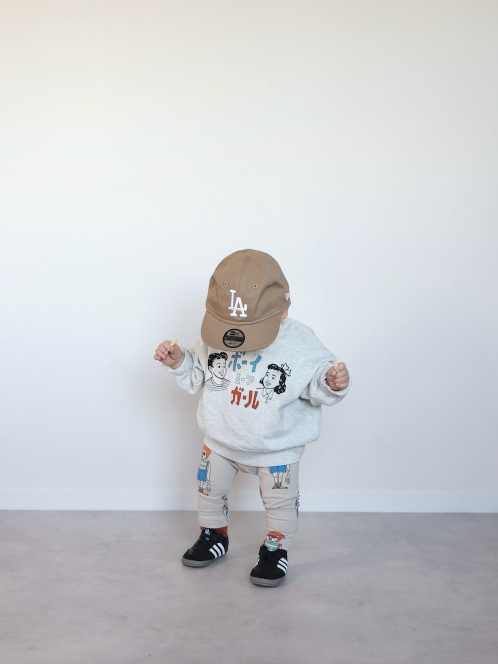 ホワイト系のスウェット、ブラック系のスニーカー、ホワイト系のレギンス/スパッツを着用したキッズの冬コーディネートの5枚目の写真