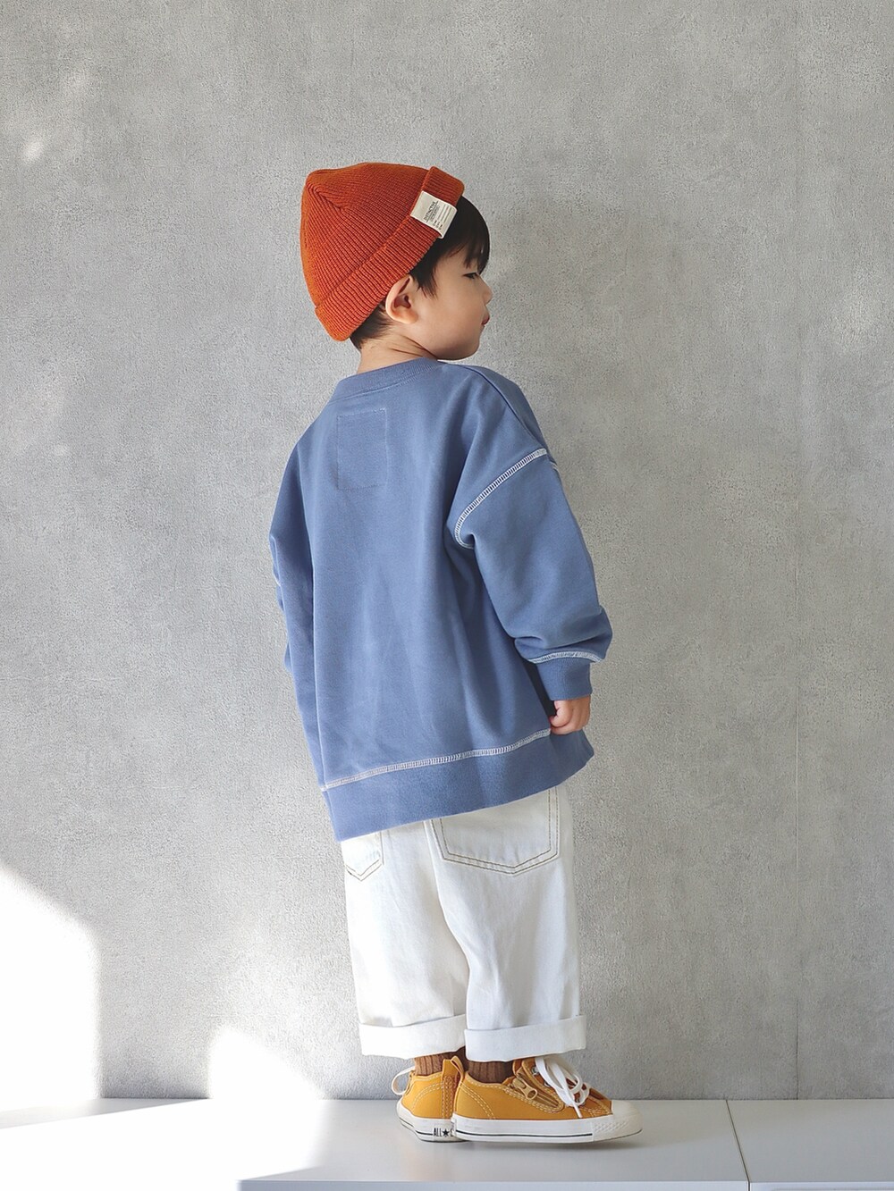 ホワイト系のデニムパンツ、イエロー系のスニーカー、ブルー系のTシャツ/カットソーを着用したキッズの冬コーディネートの4枚目の写真