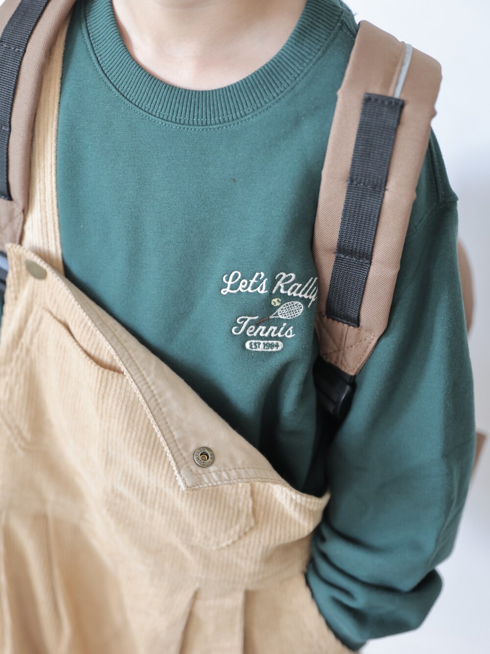 グリーン系のトップス、イエロー系のサロペット/オーバーオール、ベージュ系のシューズを着用したキッズの秋コーディネートの4枚目の写真