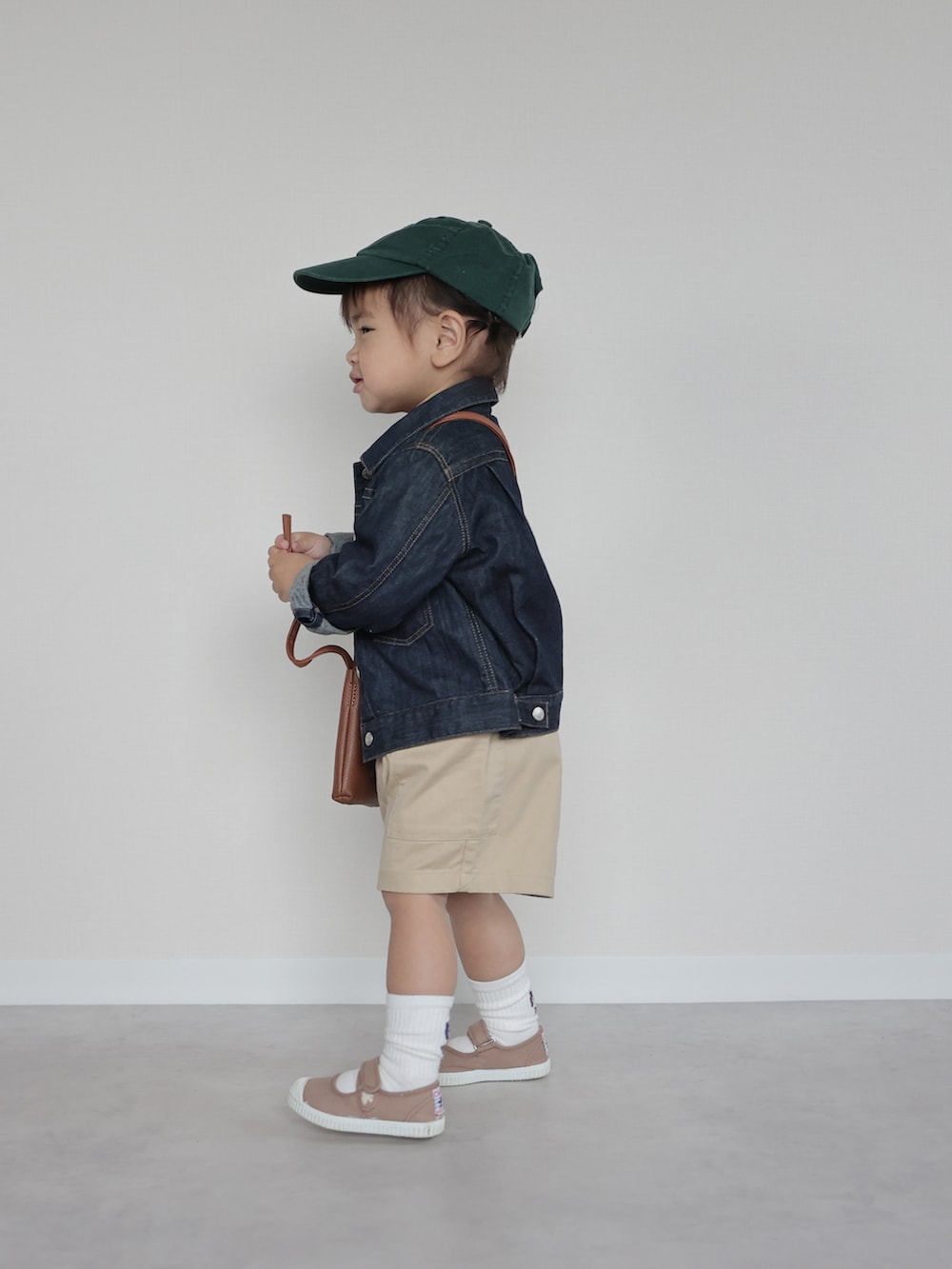 ブルー系のデニムジャケット、ホワイト系のトップス、ベージュ系のパンツを着用したキッズの春コーディネートの2枚目の写真