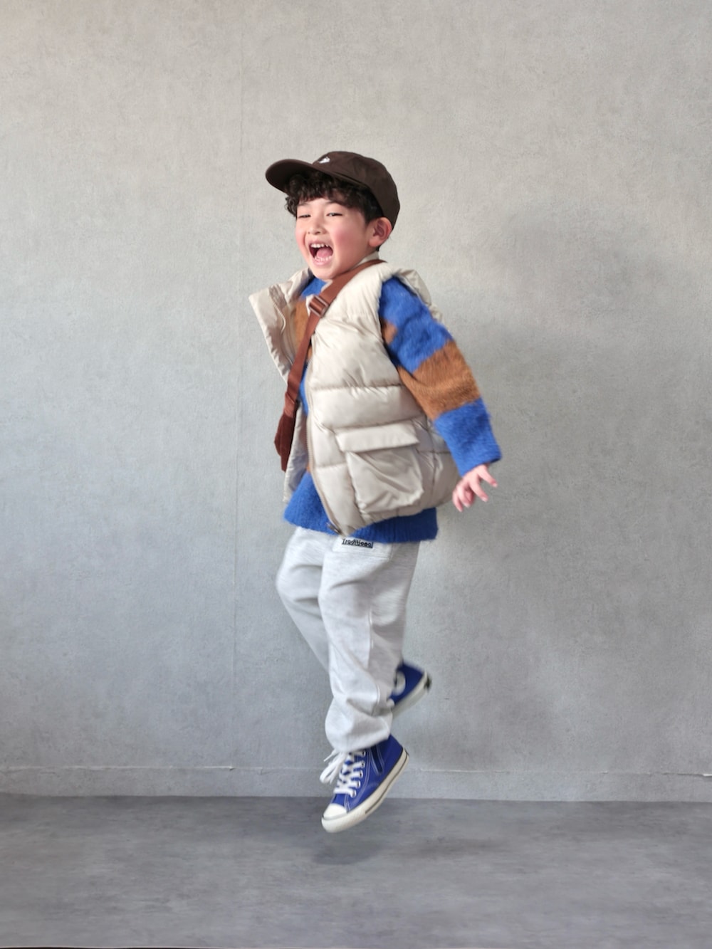 ホワイト系のベスト、ブルー系のニット/セーター、ベージュ系のその他パンツを着用したキッズの冬コーディネートの4枚目の写真