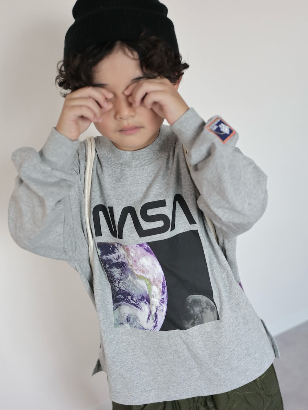 グレー系のTシャツ/カットソー、グリーン系のその他パンツ、ブラック系のスニーカーを着用したキッズの秋コーディネートの5枚目の写真