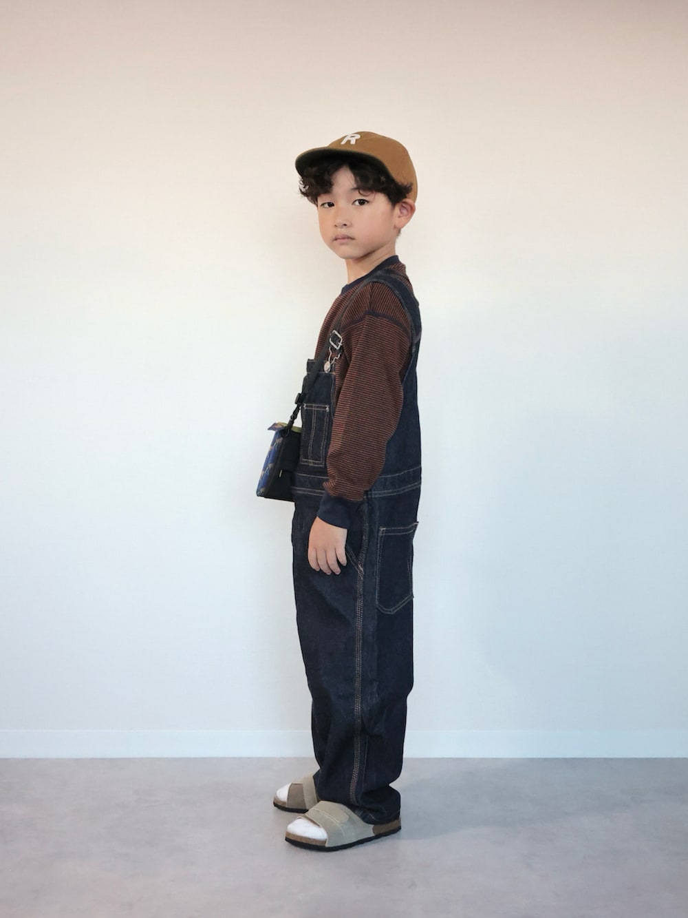 ブルー系のサロペット/オーバーオール、ベージュ系のサンダル、ブラウン系のTシャツ/カットソーを着用したキッズの夏コーディネートの4枚目の写真