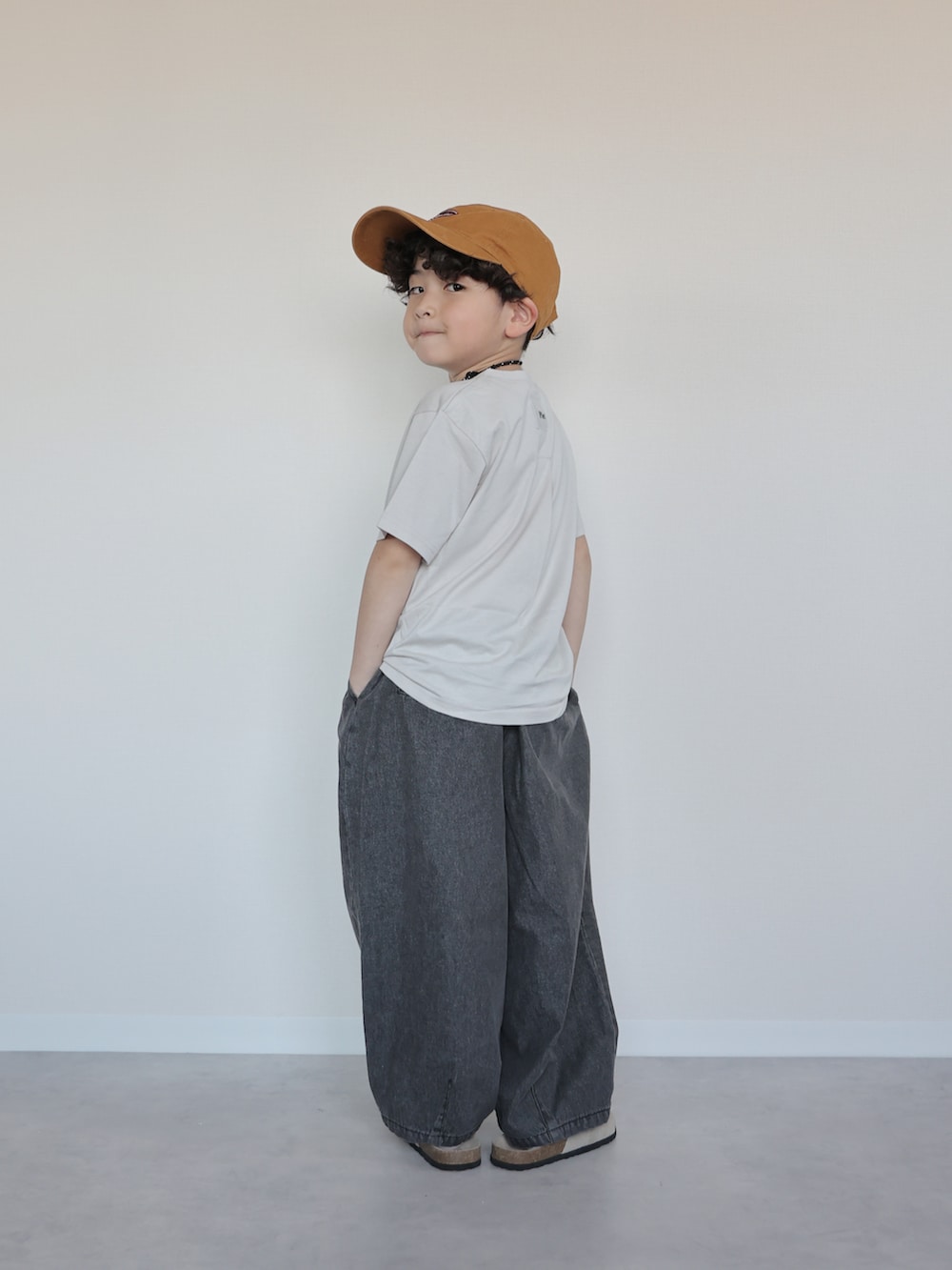 グレー系のTシャツ/カットソー、ブラック系のデニムパンツ、ベージュ系のサンダルを着用したキッズの春コーディネートの5枚目の写真