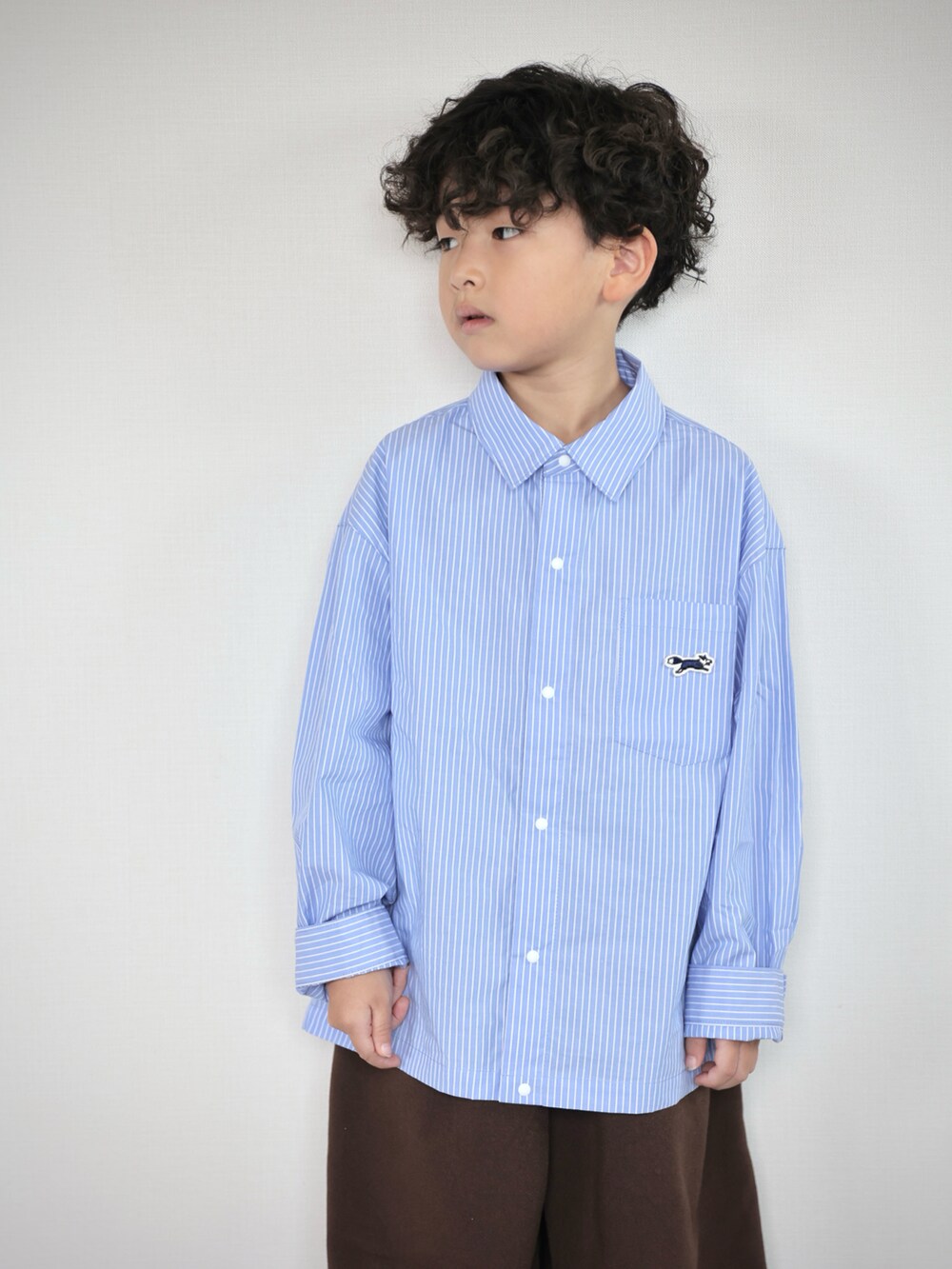 ブルー系のシャツ/ブラウス、ブラウン系のその他パンツ、グレー系のスニーカーを着用したキッズの秋コーディネートの4枚目の写真