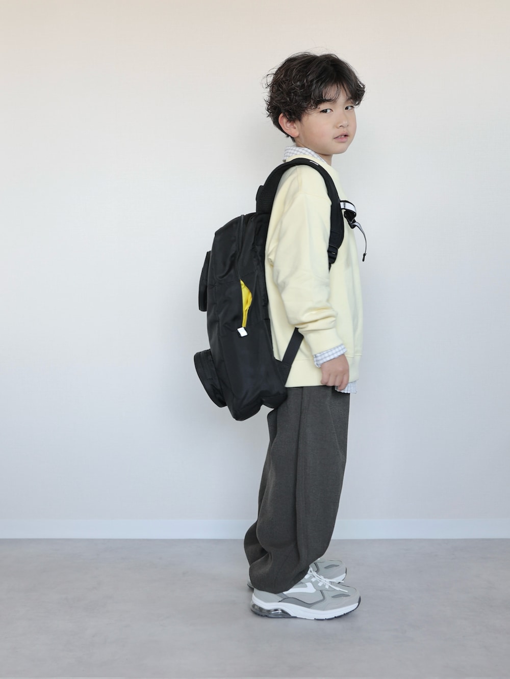 イエロー系のトップス、ホワイト系のシャツ/ブラウス、グレー系のその他パンツを着用したキッズの春コーディネートの3枚目の写真