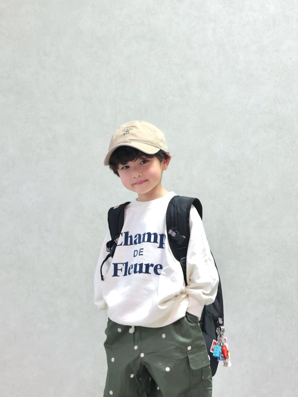 ホワイト系のスウェット、グリーン系のカーゴパンツ、ブルー系のスニーカーを着用したキッズの冬コーディネートの2枚目の写真