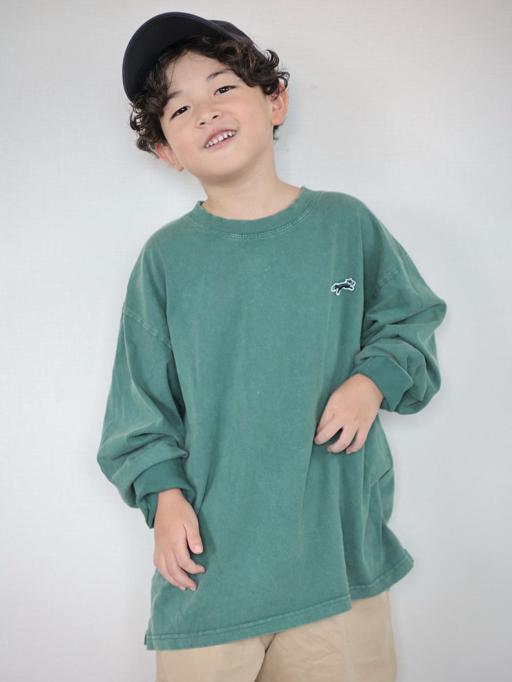 グリーン系のTシャツ/カットソー、ベージュ系のその他パンツ、ブルー系のスニーカーを着用したキッズの秋コーディネートの2枚目の写真