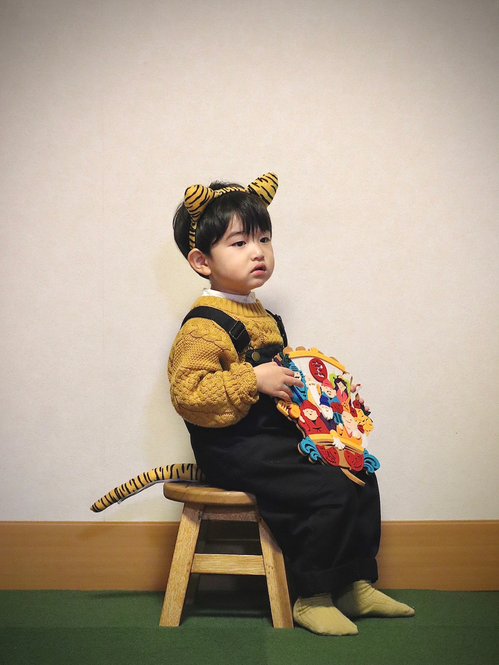 イエロー系のニット/セーター、ホワイト系のシャツ/ブラウス、ブラック系のデニムパンツを着用したキッズの冬コーディネートの5枚目の写真