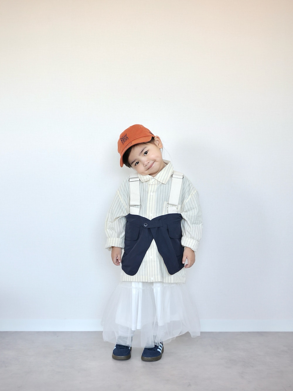 イエロー系のシャツ/ブラウス、ブルー系のベスト、ホワイト系のスカートを着用したキッズの春コーディネートの2枚目の写真