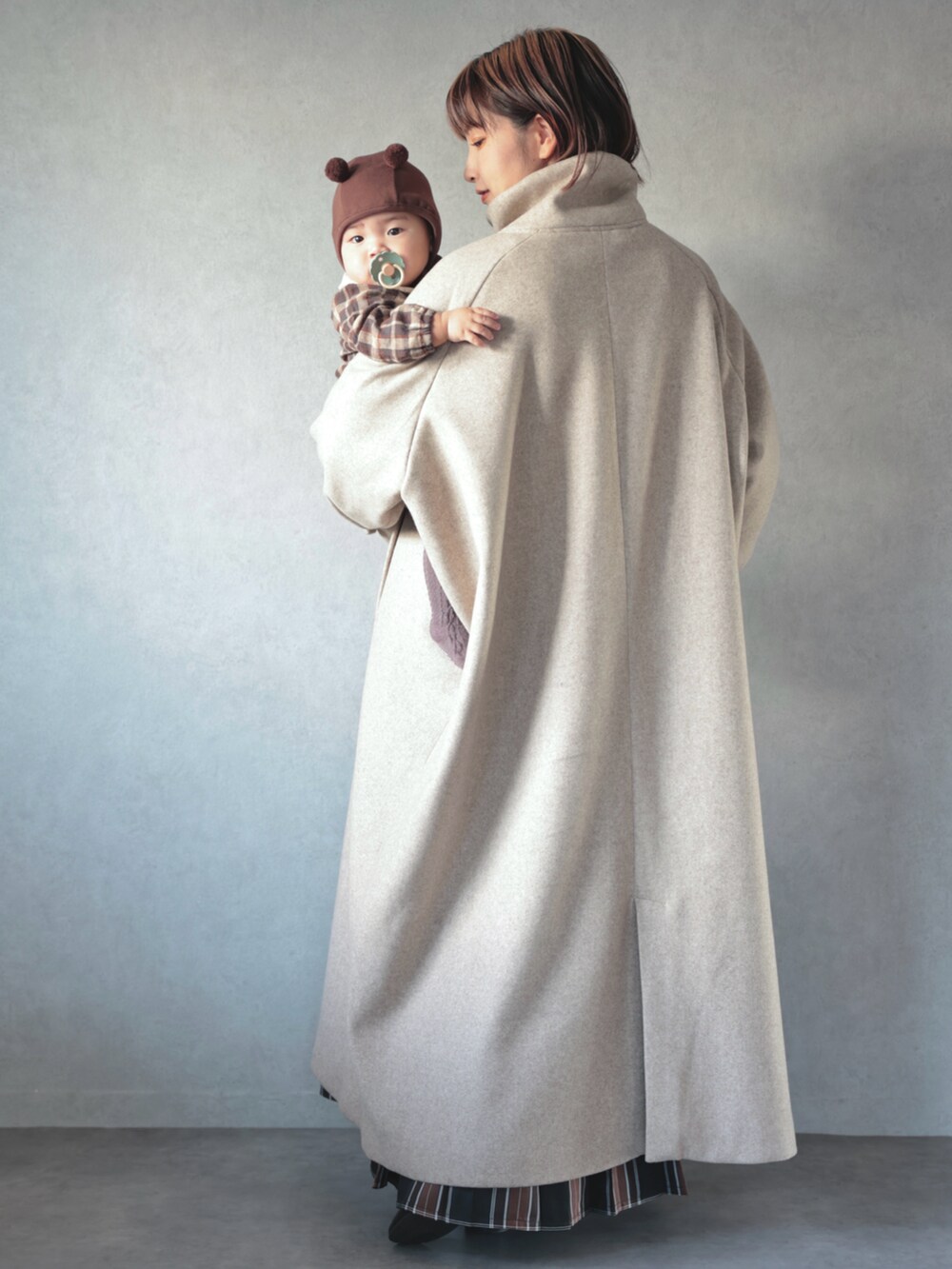 ベージュ系のその他アウター、ホワイト系のニット/セーター、ブラウン系のスカートを着用したキッズの秋コーディネートの3枚目の写真