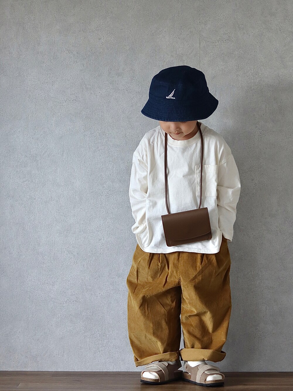 ホワイト系のTシャツ/カットソー、ブラウン系のパンツ、ベージュ系のサンダルを着用したキッズの秋コーディネートの2枚目の写真