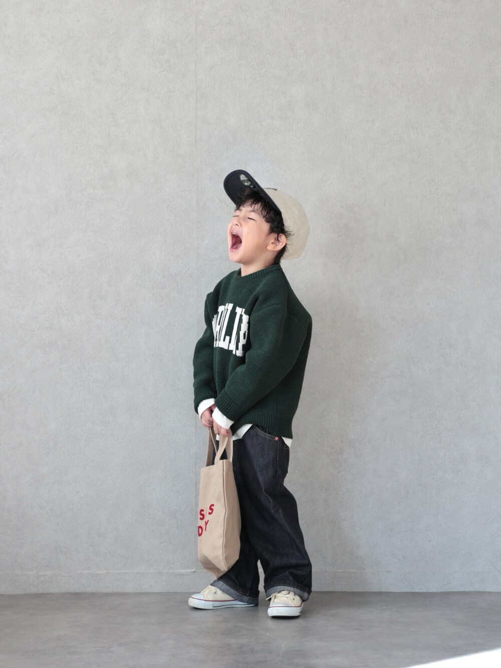 グリーン系のニット/セーター、ホワイト系のTシャツ/カットソー、ブラック系のパンツを着用したキッズの冬コーディネートの4枚目の写真