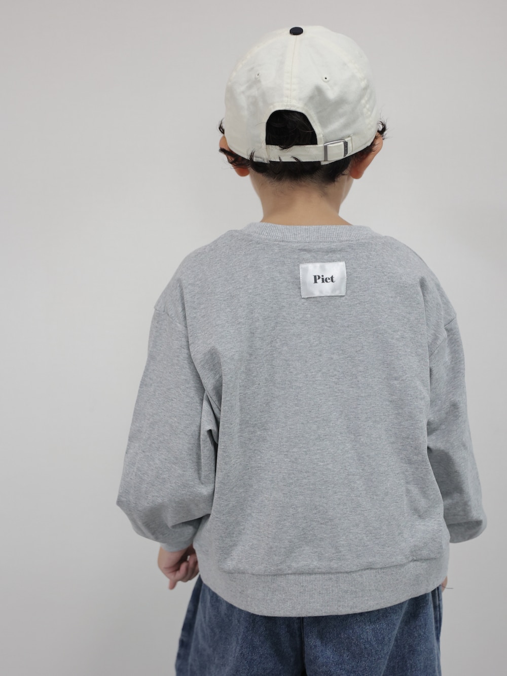グレー系のTシャツ/カットソー、ブルー系のデニムパンツ、グレー系のスニーカーを着用したキッズの秋コーディネートの4枚目の写真