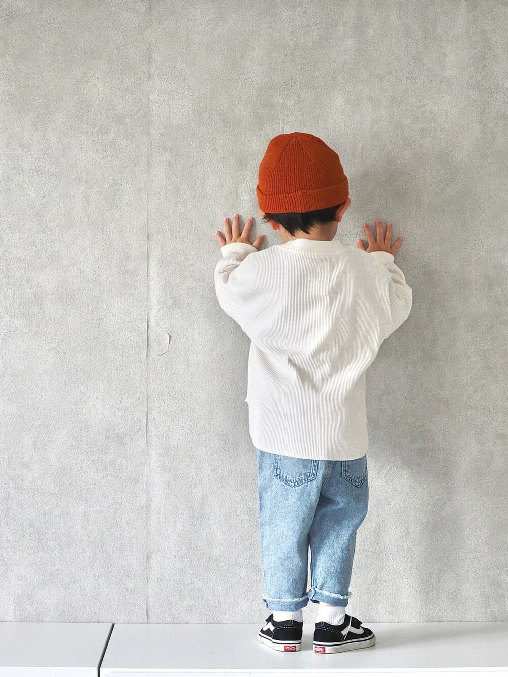 ホワイト系のTシャツ/カットソー、ブルー系のデニムパンツ、ブラック系のスニーカーを着用したキッズの冬コーディネートの4枚目の写真