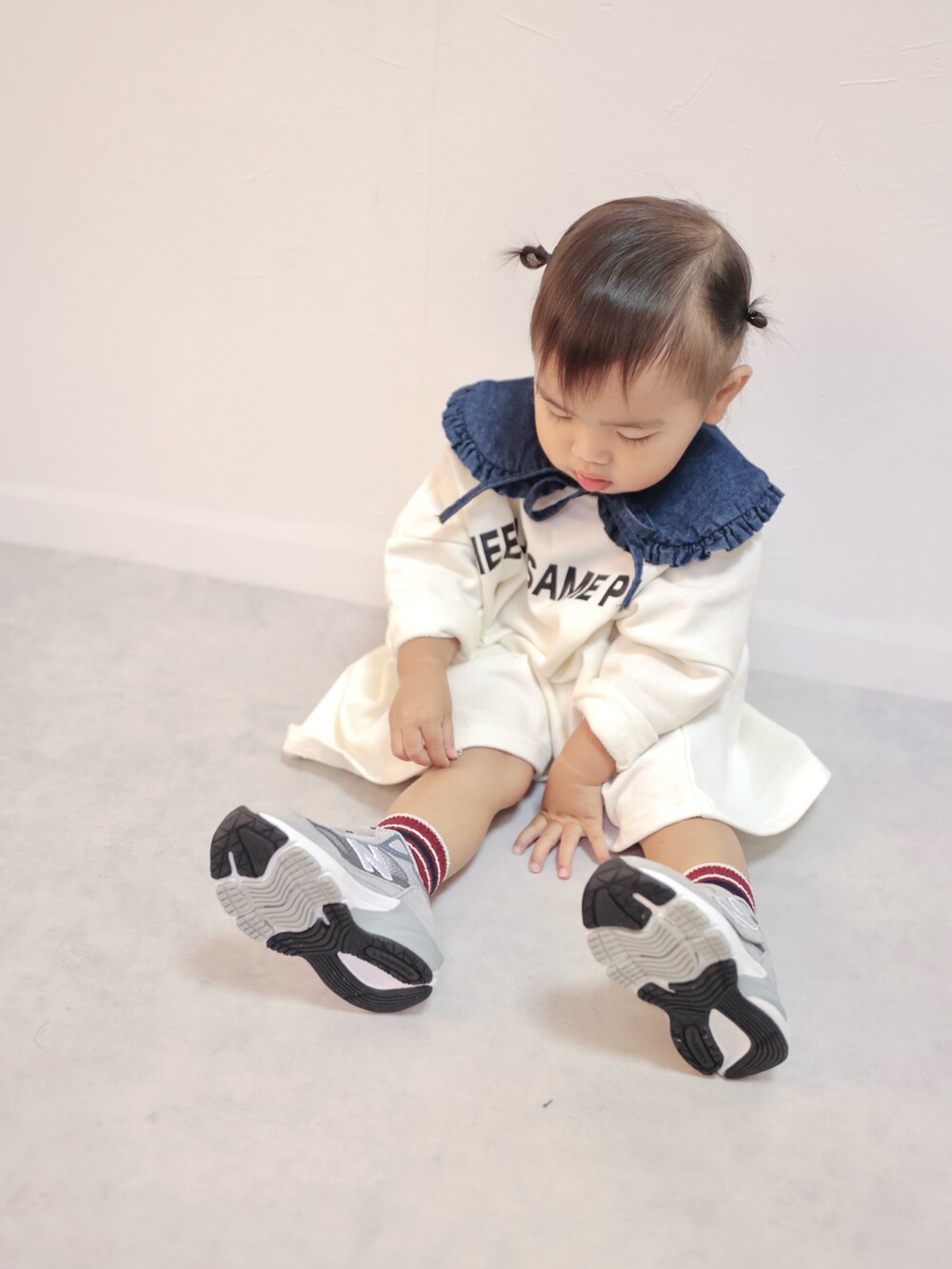 ホワイト系のワンピース、グレー系のスニーカー、ブルー系の付け襟を着用したキッズの秋コーディネートの5枚目の写真