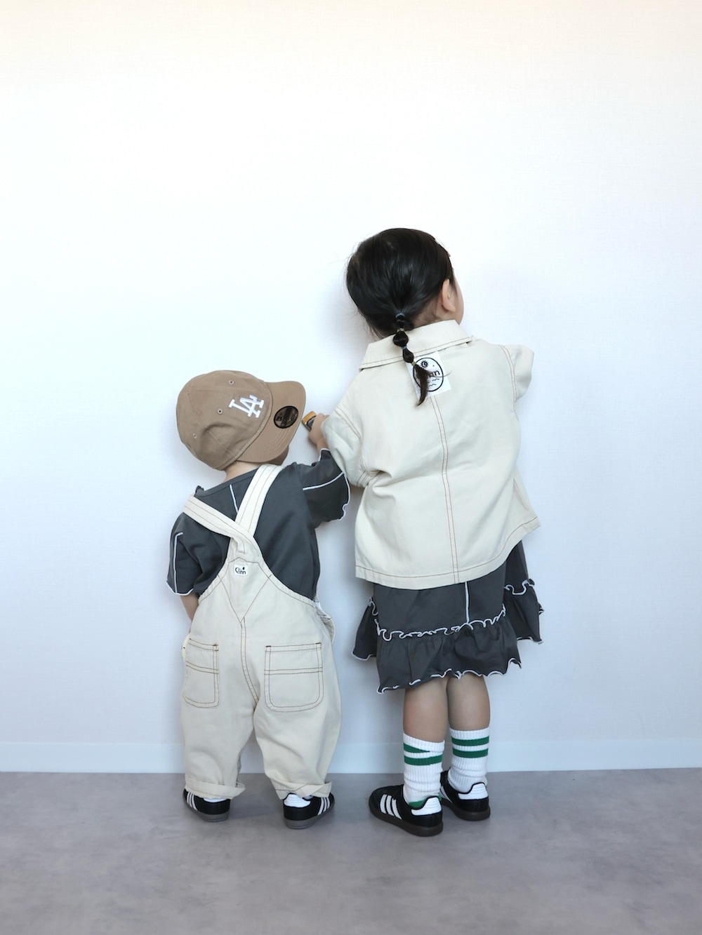 グレー系のワンピース、ブラック系のスニーカー、ブラック系のスニーカーを着用したキッズの春コーディネートの2枚目の写真