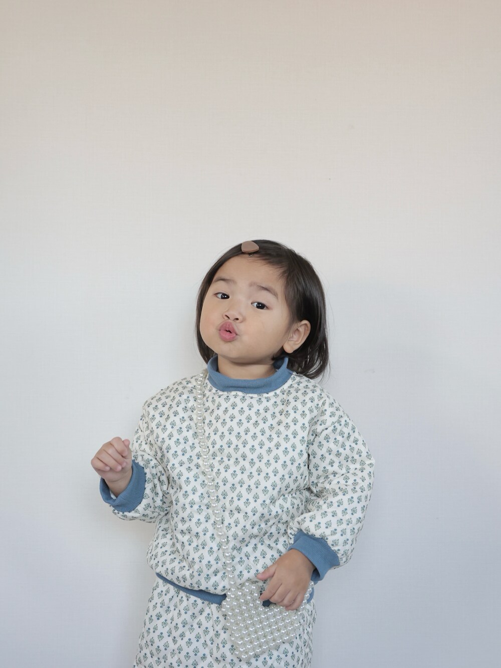 ブラウン系のモカシン/デッキシューズ、ホワイト系のセットアップ、グレー系のその他アウターを着用したキッズの秋コーディネートの5枚目の写真