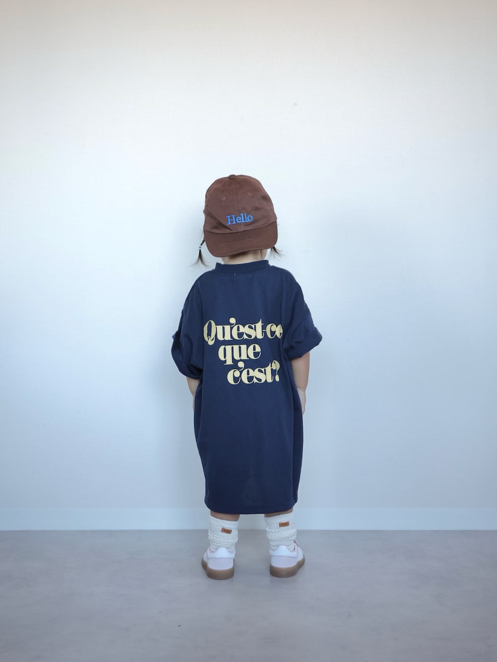 ブルー系のワンピース、ピンク系のスニーカー、ブラウン系のキャップを着用したキッズの夏コーディネートの5枚目の写真