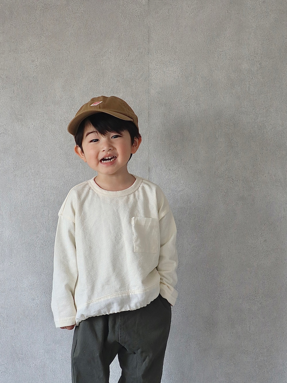 ブラウン系のカーディガン/ボレロ、ホワイト系のTシャツ/カットソー、グリーン系のその他パンツを着用したキッズの冬コーディネートの2枚目の写真