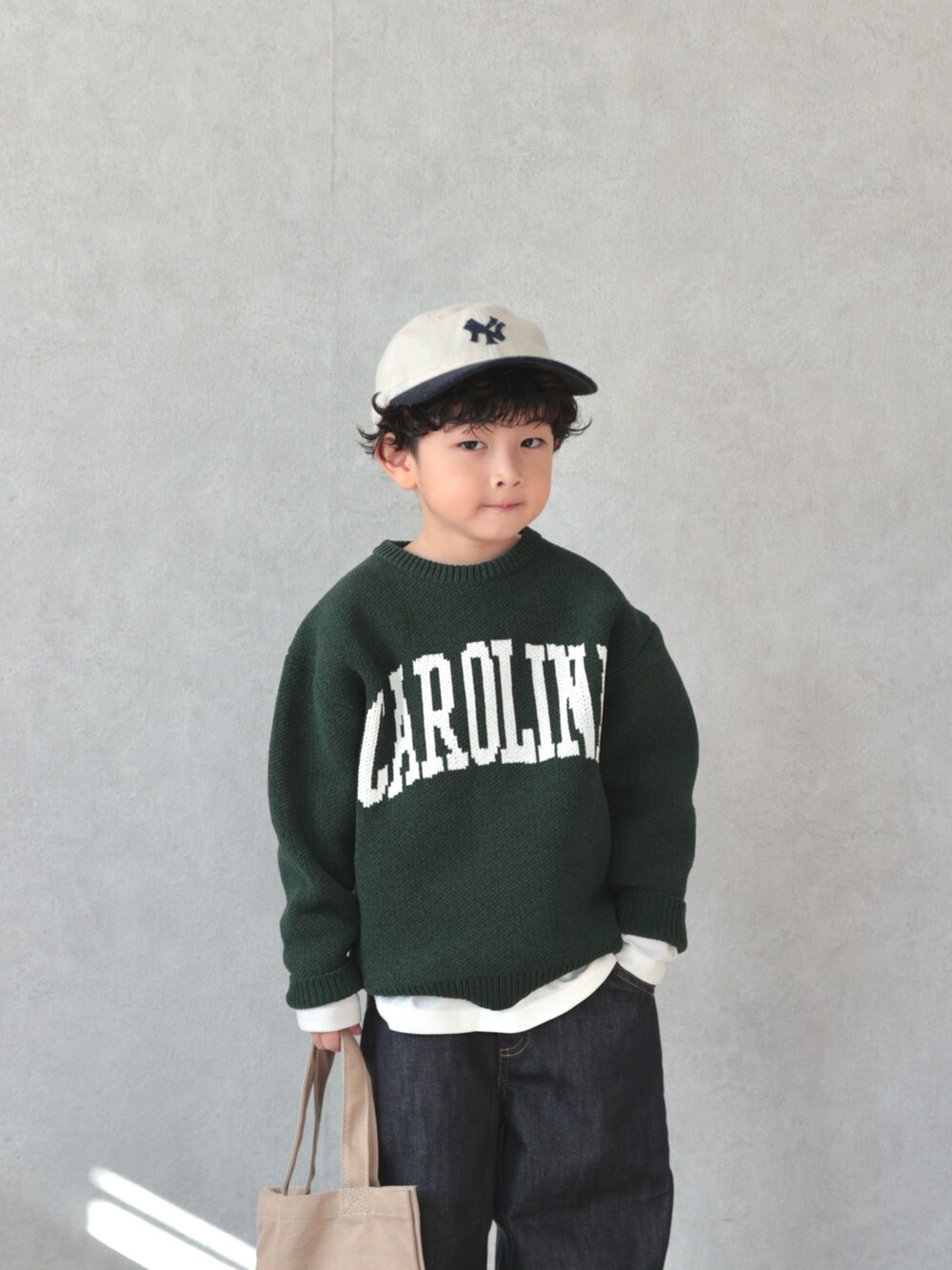 グリーン系のニット/セーター、ホワイト系のTシャツ/カットソー、ブラック系のパンツを着用したキッズの冬コーディネートの5枚目の写真