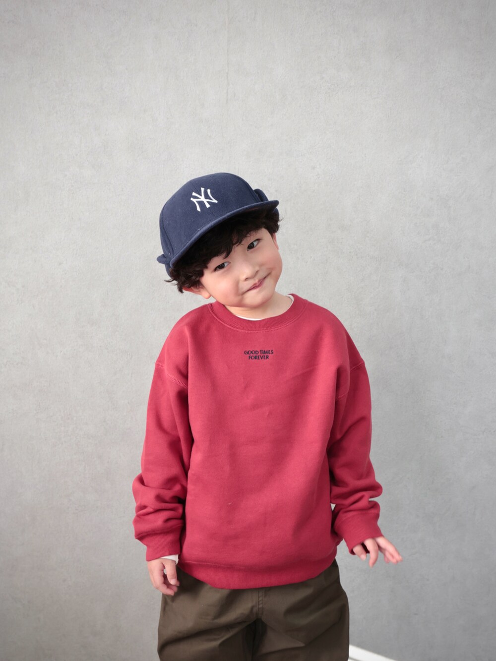 レッド系のスウェット、グリーン系のその他パンツ、ホワイト系のTシャツ/カットソーを着用したキッズの冬コーディネートの2枚目の写真