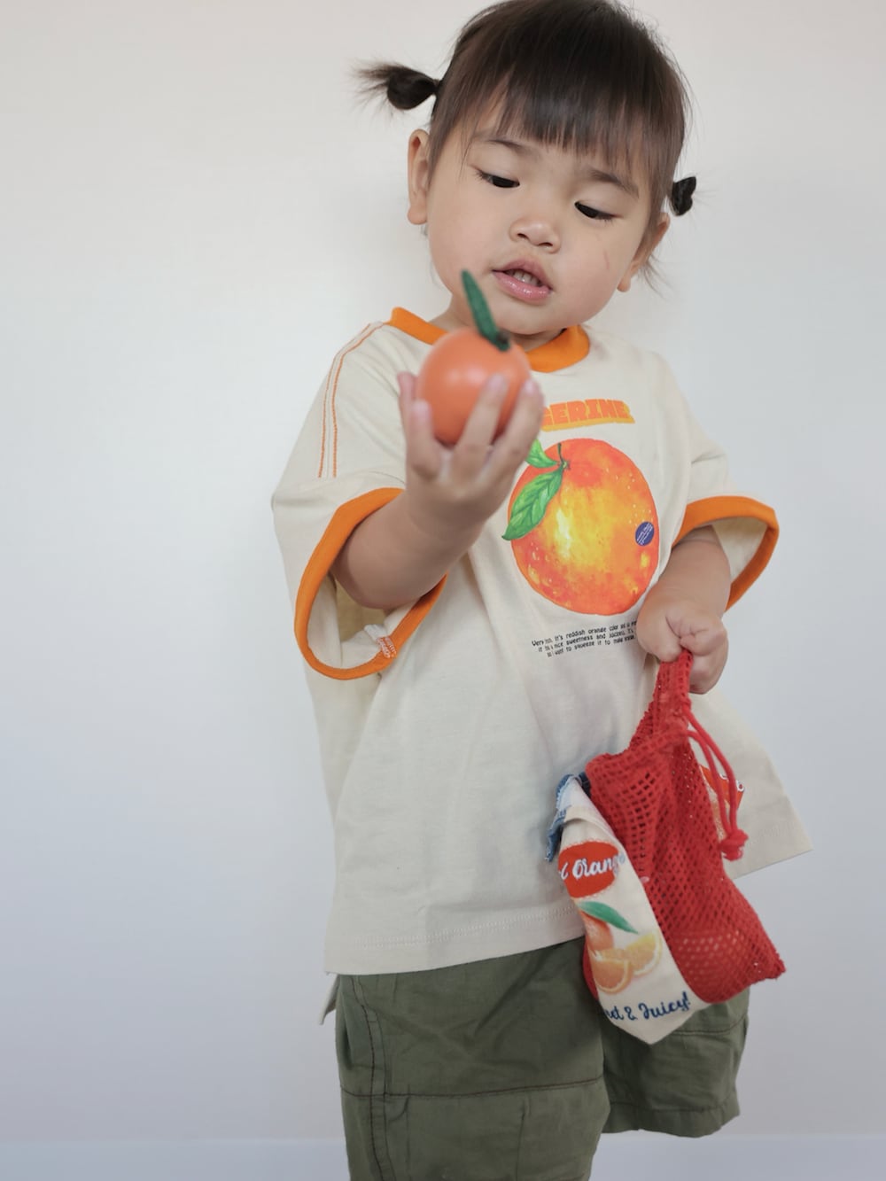 ベージュ系のTシャツ/カットソー、グリーン系のその他パンツ、ブラック系のスニーカーを着用したキッズの春コーディネートの3枚目の写真