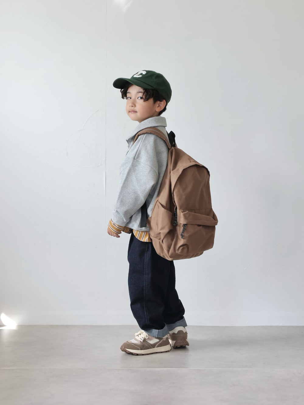 グレー系のスウェット、イエロー系のシャツ/ブラウス、ブルー系のデニムパンツを着用したキッズの秋コーディネートの4枚目の写真